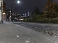 an empty sidewalk with no people walking or sitting in it at night on the sidewalk