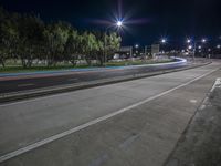 the night view of an empty street lit up by street lights and street lights on either side of the road