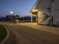 this is a farm entrance with a lamp over it's door and the lights are on