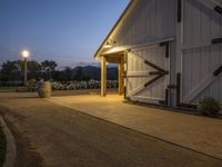 this is a farm entrance with a lamp over it's door and the lights are on