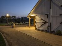 this is a farm entrance with a lamp over it's door and the lights are on