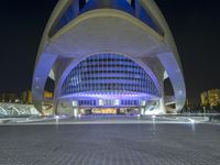a view of the city's futuristic architecture at night, including an entrance that is covered in blue lights