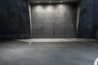 a empty concrete building with the floor made of concrete and the entrance is painted a black color