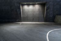 a empty concrete building with the floor made of concrete and the entrance is painted a black color