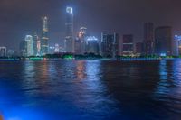 a city street with buildings and neon lights at night time in hong china as seen from an empty city highway