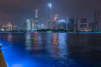 a city street with buildings and neon lights at night time in hong china as seen from an empty city highway