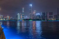 a city street with buildings and neon lights at night time in hong china as seen from an empty city highway