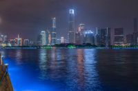 a city street with buildings and neon lights at night time in hong china as seen from an empty city highway