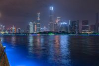 a city street with buildings and neon lights at night time in hong china as seen from an empty city highway