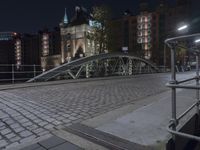 there is a bridge that leads to a street at night over water near the city of boston