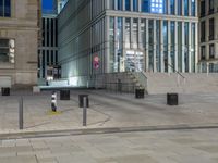 a walkway leading up to some buildings at night and no parking spaces for people to walk on