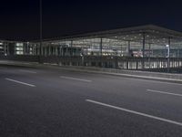 the building is very large and has many windows and is lighted by the streetlights