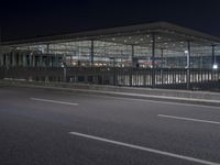 the building is very large and has many windows and is lighted by the streetlights