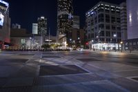 a very big empty area at night, with buildings in the background and traffic light on