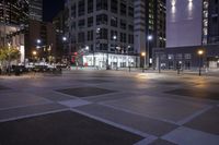 a very big empty area at night, with buildings in the background and traffic light on