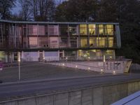 an empty parking lot with stairs in front of it at dusk with street lights on