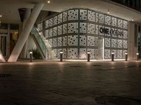 an image of a building that is lit up at night with multiple lights above it