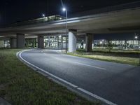 a bridge with cars going over it on an empty road at night in the city