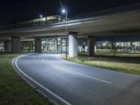 a bridge with cars going over it on an empty road at night in the city