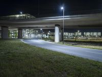 a bridge with cars going over it on an empty road at night in the city