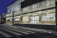 some very pretty buildings in the dark of night with lights on them and steps going to the side