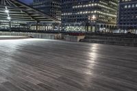 a view of new york city skyline at night from pier on the hudson river side