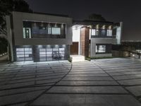 a modern home lit up with led lights, and the driveway is well paved for access