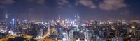 view of an urban city from atop of skyscrapers and other buildings in the night