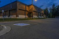 an empty parking lot sits in front of an office building at night in a suburban setting