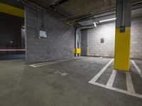 a parking garage with an exit door in it and a parking lot floor painted yellow