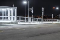 some parking lot with lights and street lights lit up at night time in the foreground