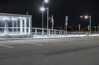 some parking lot with lights and street lights lit up at night time in the foreground