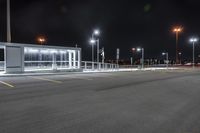 some parking lot with lights and street lights lit up at night time in the foreground