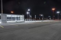 some parking lot with lights and street lights lit up at night time in the foreground