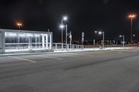 some parking lot with lights and street lights lit up at night time in the foreground