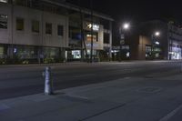 a closed parking space is located on a city street at night, with lights in the background