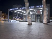 a square in the middle of a large city with people walking on it at night