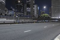 the view of skyscrapers from the highway at night shows city street with a traffic light