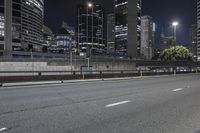 the view of skyscrapers from the highway at night shows city street with a traffic light