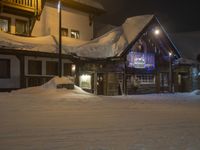 a building is in the snow outside a ski resort at night, with light lite up