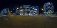 the night view of a street and an outside office building with a curved entrance at night