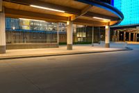 a street near an airport at night with lights on the buildings and blue glass windows