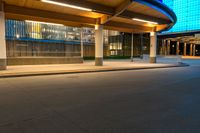 a street near an airport at night with lights on the buildings and blue glass windows