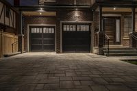 a brick driveway in front of a house at night with two car doors and one door opened