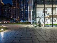 a photo taken of a courtyard area at night with a christmas tree outside a large building