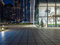 a photo taken of a courtyard area at night with a christmas tree outside a large building