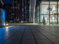 a photo taken of a courtyard area at night with a christmas tree outside a large building