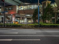 an image of outside of the night time building with the lights turned on and the streets empty