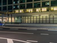 an image of outside of the night time building with the lights turned on and the streets empty