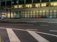 an image of outside of the night time building with the lights turned on and the streets empty